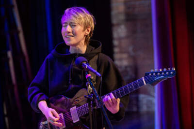 Cloudbelly singer-songwriter Corey Laitman plays guitar with the group at the Shea Theater Arts Center in Turners Falls, Mass. (Robin Lubbock/WBUR)