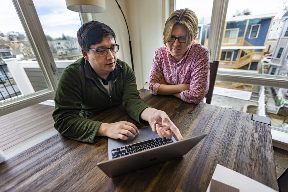 Peter Ott, left, and his partner, Ben Wilson, review closing documents for their new home in Dorchester. (Jesse Costa/WBUR)