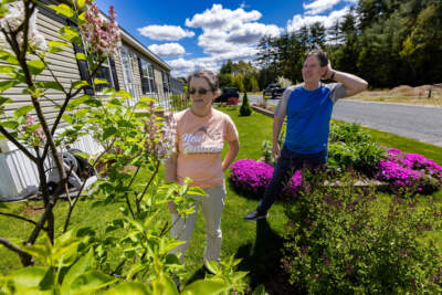 Ed and Rose Bartok marvel at how well their lilac bush is growing in the front yard of their home at the Miller’s Woods and River Bend community in Athol. (Jesse Costa/WBUR)