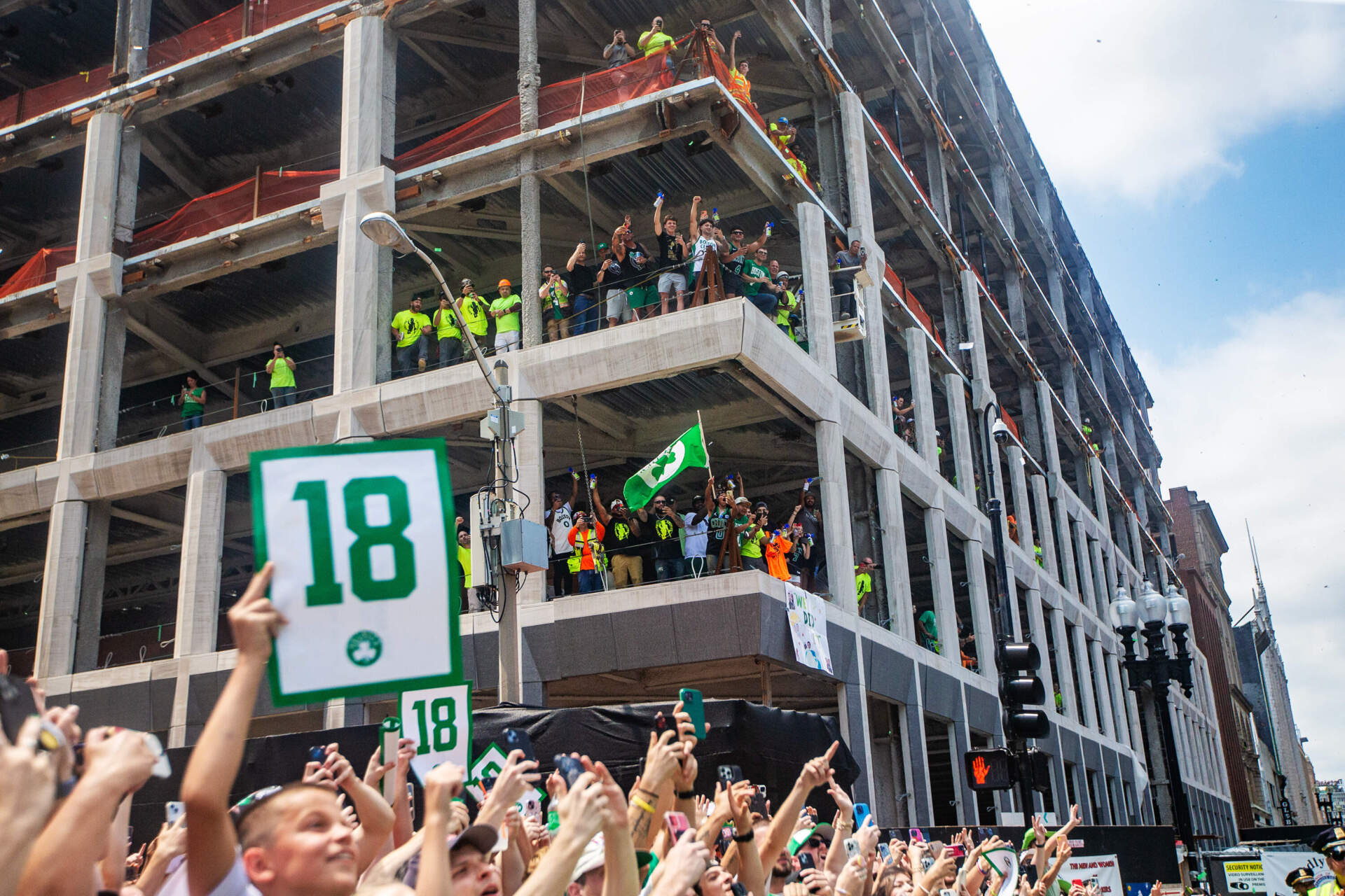 Construction works halt work to celebrate as the Celtics rolling rally passes by on Boylston Street. (Jesse Costa/WBUR)