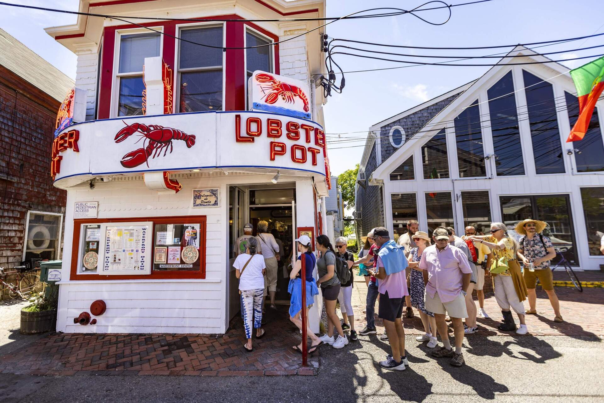 A long line of tourists enters the Lobster Pot in Provincetown in 2022. (Jesse Costa/WBUR file photo)