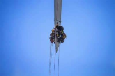 Technicians of the Block Island Wind Farm support team repair a crack in the blade of one of the wind turbines. (Jesse Costa/WBUR)