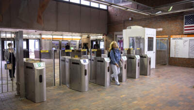 A passenger walks through the turnstile at the MBTA's Green Street station. (Robin Lubbock/WBUR)