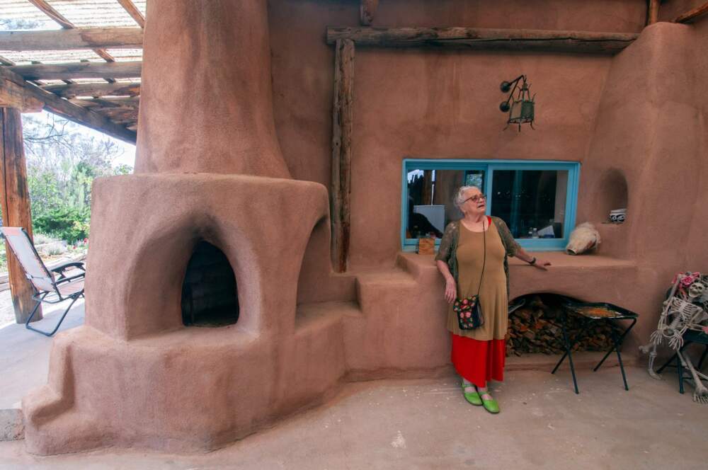 Anita Otilia Rodríguez on her back patio at her home in Taos, New Mexico with her wood-fired oven. (Chris Bentley/Here & Now)