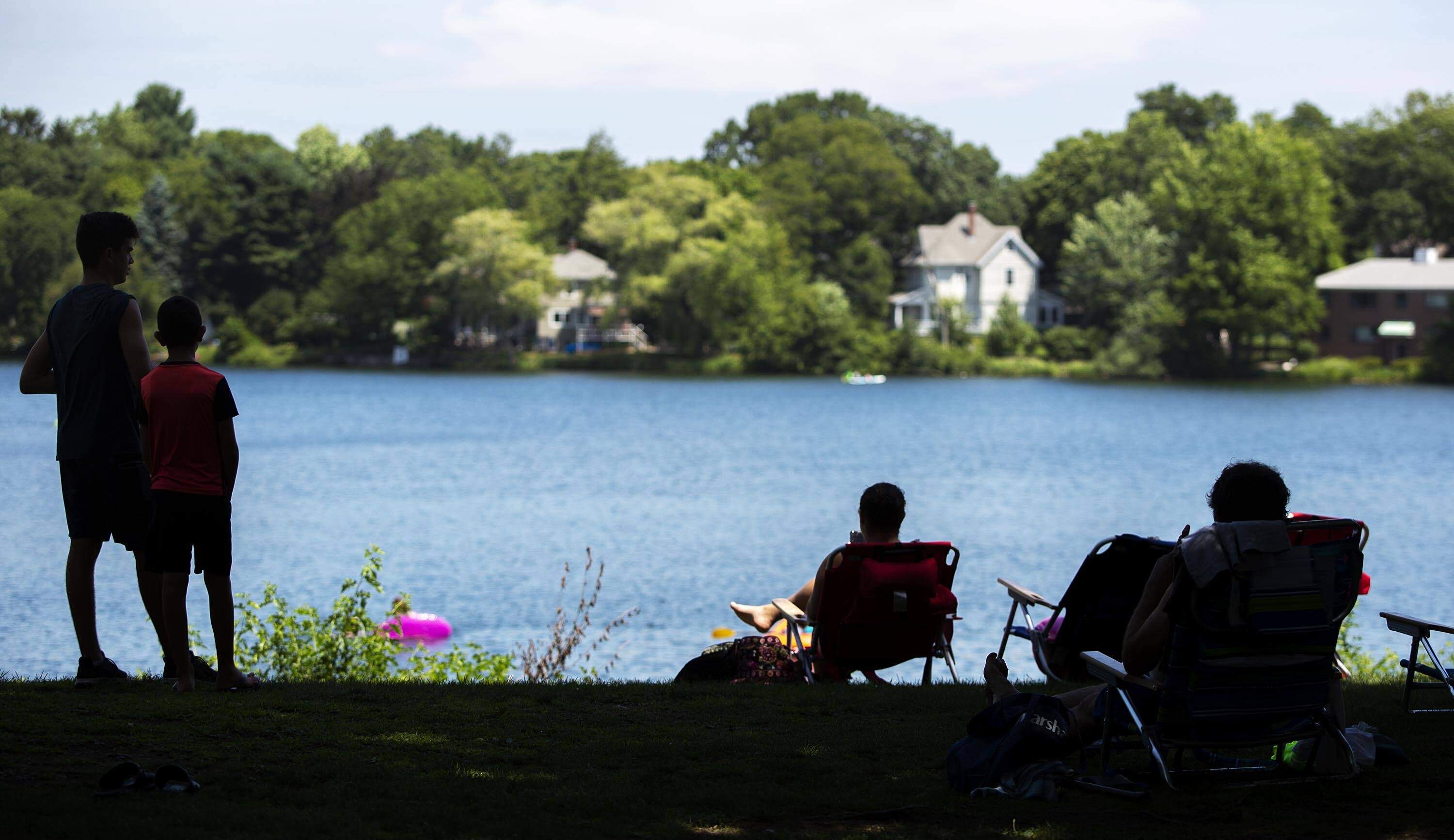 Visitors to Crystal Lake in Newton stay in the shade to keep out of the heat. (Robin Lubbock/WBUR)