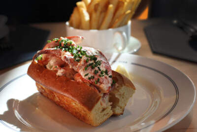 A chilled lobster roll with fries from The Oyster Club in Park Square in Boston. (Photo by Suzanne Kreiter/The Boston Globe via Getty Images)