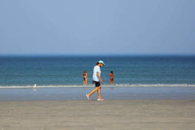 A woman walks on Nahant Beach during a hot day in Boston, Mass. on May 26, 2021. (Anik Rahman/NurPhoto via Getty Images)