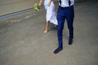 A bride and groom walk along a city street. (Getty Images)