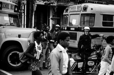 Bused Black schoolchildren arrive with police escort at South Boston High School during court-ordered desegregation in 1974. (Spencer Grant/Getty Images)
