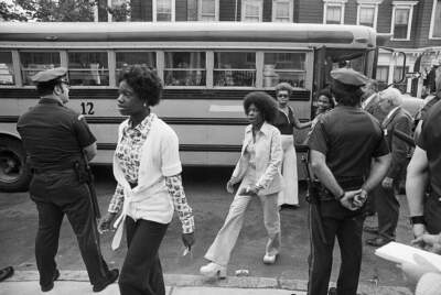 As police stand guard, Black students arrive at South Boston High School in Boston, Mass., for the first day of classes on Sept. 12, 1974. (Getty Images)