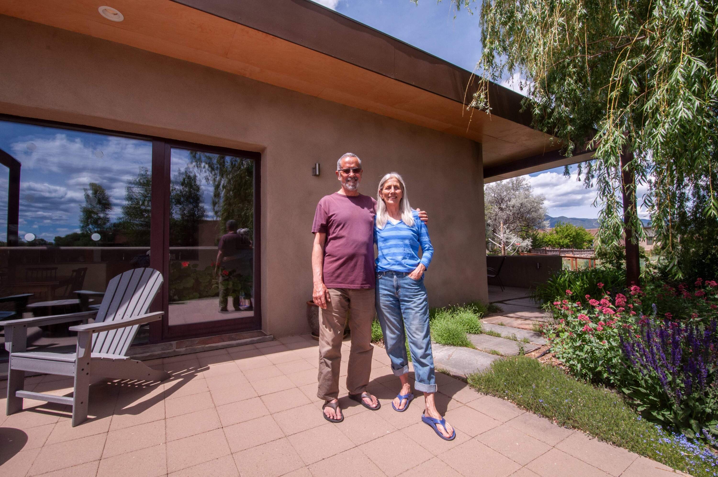 Ross and Kristin Ulibarri in front of their home in Valverde Commons, a cohousing community in Taos, New Mexico. (Chris Bentley/Here &amp; Now)